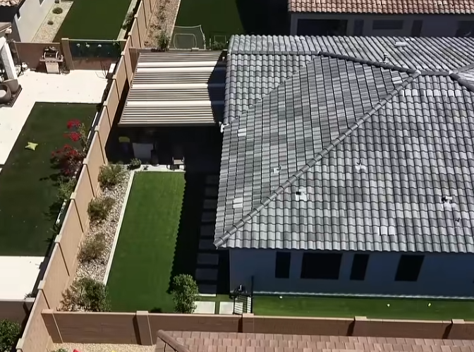 Solid roof ramada covering an Arizona backyard patio with seating and ceiling fans