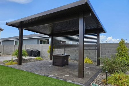 Modern pergola with spaced rafters casting striped shade over an Arizona patio